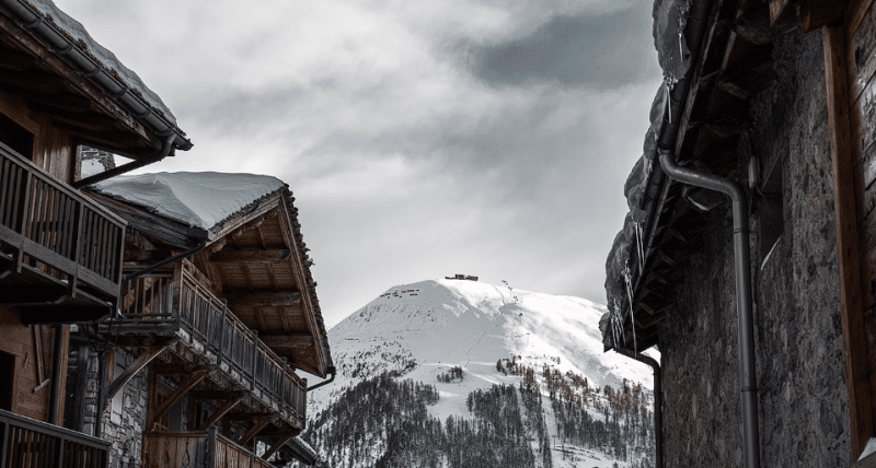 Kuće smeđe boje sa pogledom na vrh planine prekriven bijelim snijegom