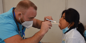 Doktor koji pregledava djevojci grlo