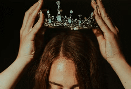 Djevojka koja stavlja krunu na svoju glavu