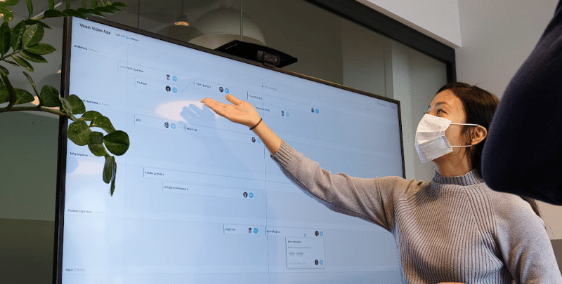 Žena koja pokazuje rukom i objasnjava svoju prezentaciju na monitoru