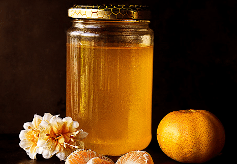 Domaći med u staklenci sa mandarinom i cvijetom pokraj