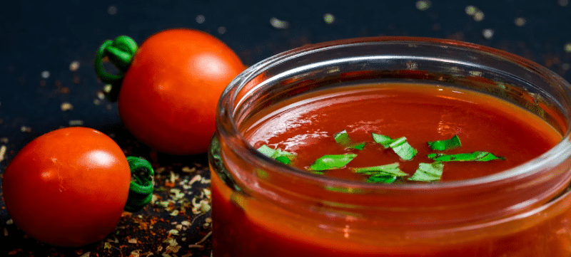 Kečap u zdjeli sa paradajzom pokraj