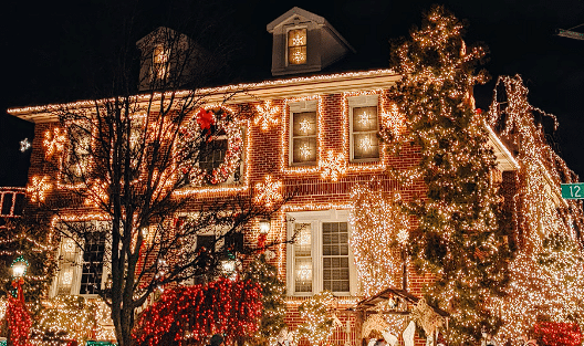 Kuća sa mnostvom Božićnih ukrasa koji svjetlucaju