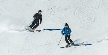 Dvije osobe skijaju niz planinu