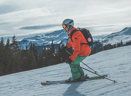 Osoba u crvenoj jakni koja skija