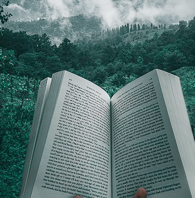 Otvorena knjiga sa prirodom u pozadini