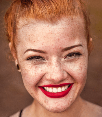 Žena sa narančastom kosom i pjegicama na licu